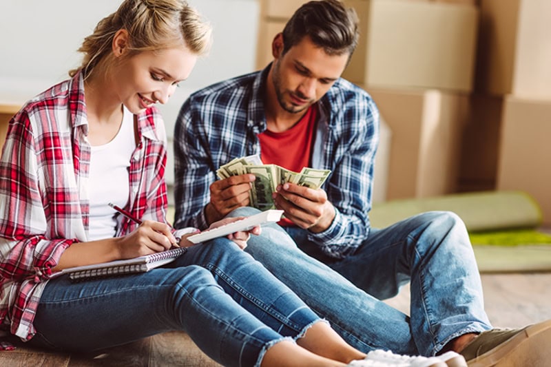 young couple counting money Young couple counting money while sitting on floor in new apartment. 2025 Is Your Last Chance to Claim Federal HVAC Tax Credits.